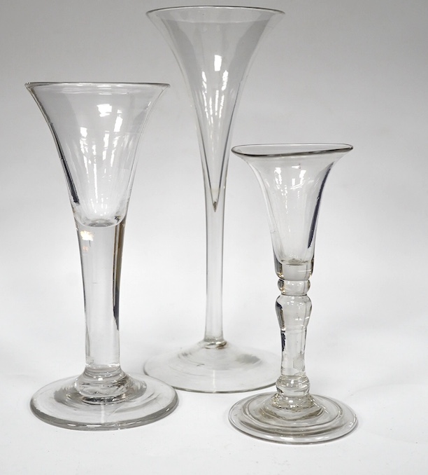 Two drawn trumpet wine glasses, late 18th century and a balustroid gin glass, c.1740, 12.4cm - 18.7cm high (3). Condition - the slender trumpet wine glass has some glue residue to the pontil mark but there is no evidence